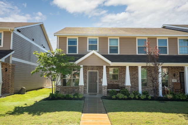 view of front facade with brick siding and a front lawn