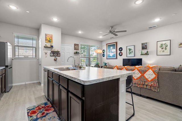 kitchen with open floor plan, a wealth of natural light, light countertops, visible vents, and freestanding refrigerator