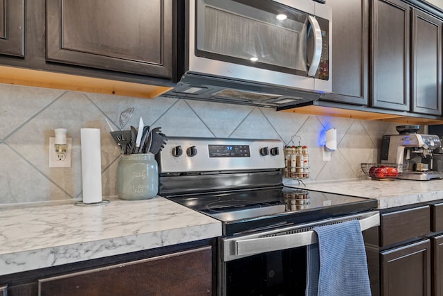 kitchen with stainless steel appliances, light countertops, and dark brown cabinetry