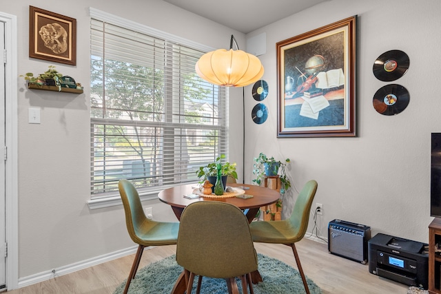 dining space featuring baseboards and light wood-style floors
