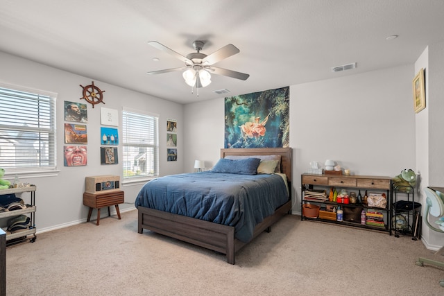 carpeted bedroom with baseboards, a ceiling fan, and visible vents