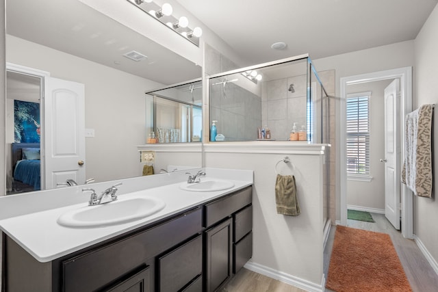 bathroom featuring wood finished floors, visible vents, and a sink