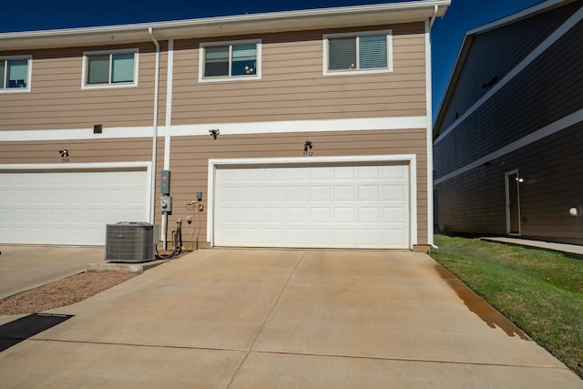 exterior space featuring a garage, concrete driveway, and central AC unit