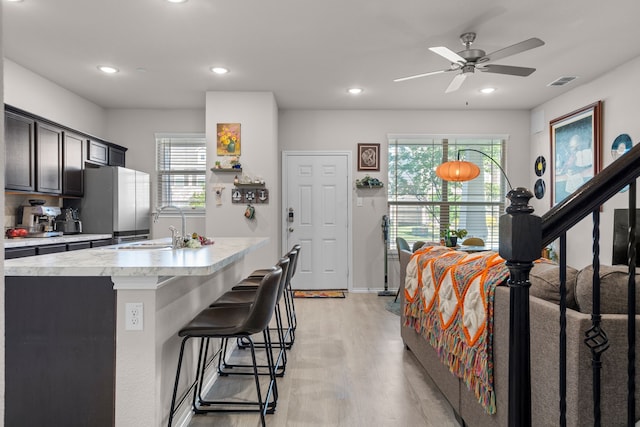 kitchen with recessed lighting, light countertops, visible vents, a sink, and light wood-style floors
