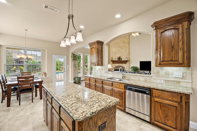 kitchen featuring a sink, dishwasher, arched walkways, a kitchen island, and visible vents