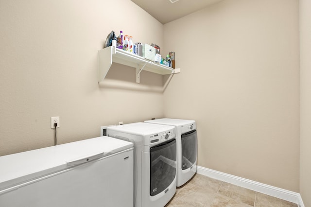 laundry area with baseboards, laundry area, and washer and clothes dryer