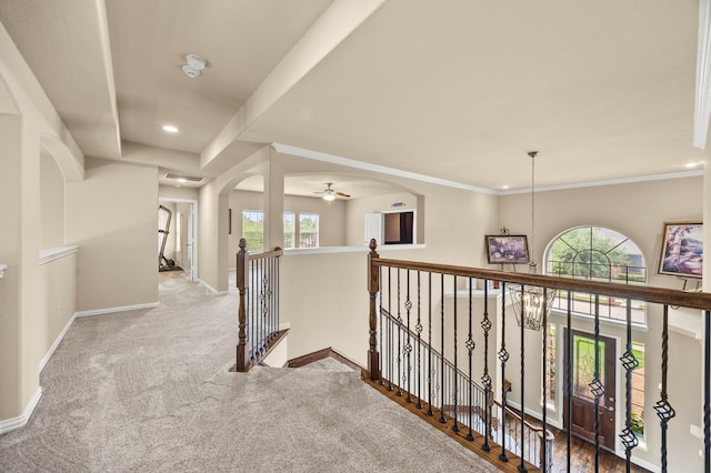 hallway featuring arched walkways, baseboards, an upstairs landing, carpet flooring, and recessed lighting