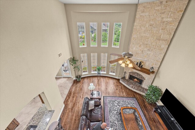 902 Alfred Dr, Wylie, TX 75098 - living area featuring a stone fireplace, arched walkways, wood finished floors, a towering ceiling, and ceiling fan