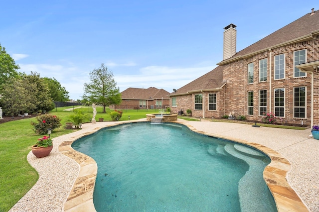 view of swimming pool featuring a lawn, a patio area, a pool with connected hot tub, and fence