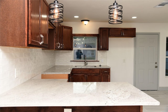 4841 Bromfield St, Dallas, TX 75216 - kitchen with decorative light fixtures, tasteful backsplash, a sink, and visible vents