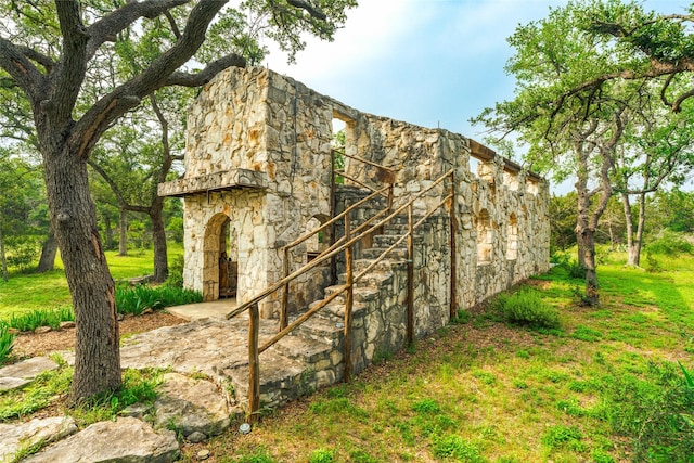 view of home's exterior with stone siding and stairway