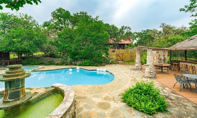 view of pool featuring outdoor dining area, fence, a fenced in pool, an in ground hot tub, and a wooden deck