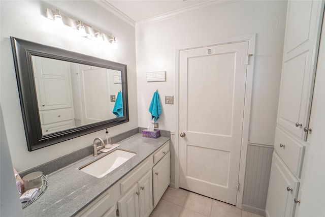 bathroom featuring wainscoting, crown molding, vanity, and tile patterned floors