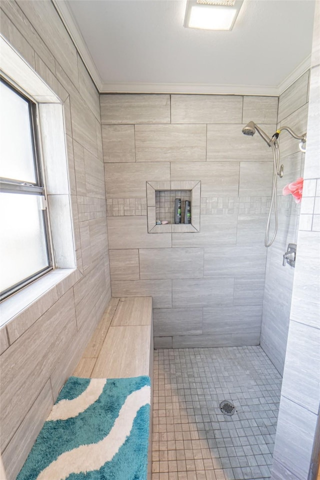 bathroom featuring crown molding, tile patterned flooring, and tiled shower