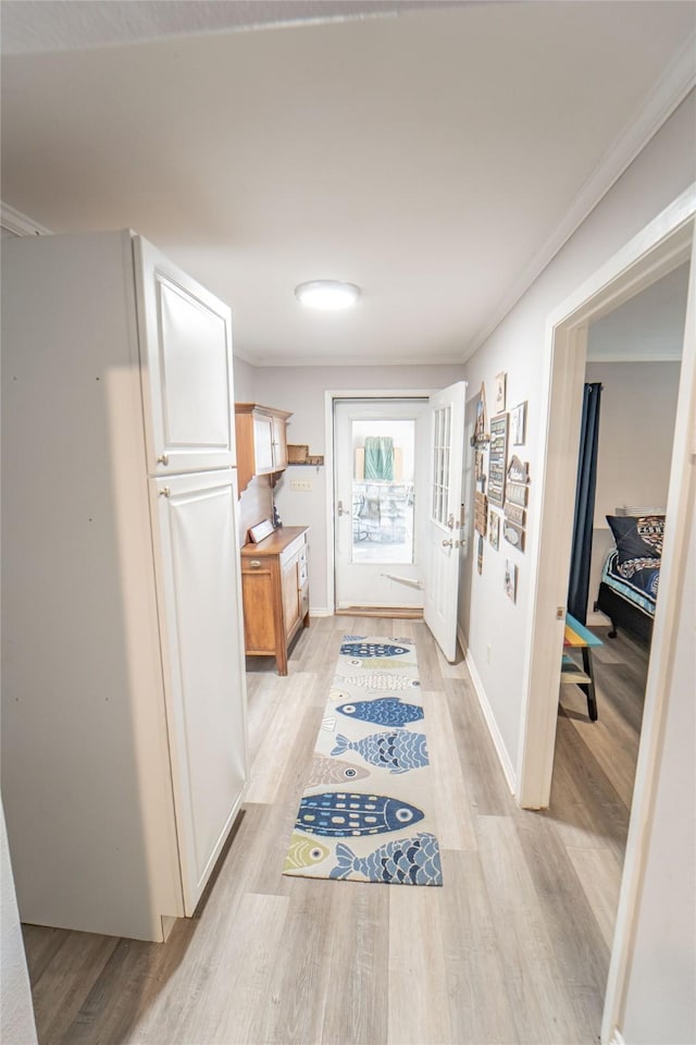 hallway featuring light wood-style floors and crown molding