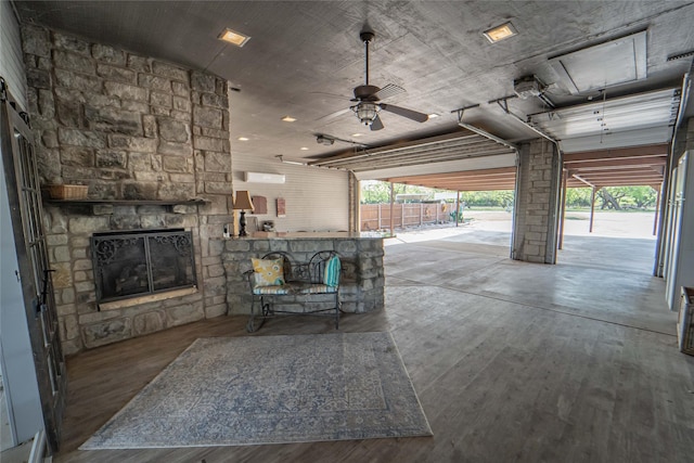 interior space with an outdoor stone fireplace and a ceiling fan