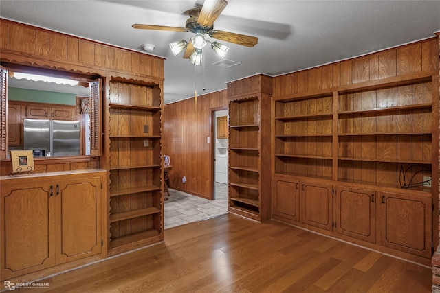 2007 Venus Dr, Bossier City, LA 71112 - unfurnished living room featuring wood walls, washer / dryer, light wood-type flooring, visible vents, and a ceiling fan