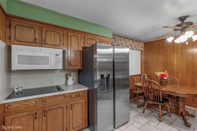 2007 Venus Dr, Bossier City, LA 71112 - kitchen with brown cabinetry, black electric stovetop, white microwave, ceiling fan, and stainless steel fridge with ice dispenser
