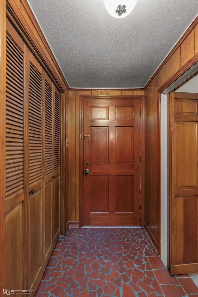 2007 Venus Dr, Bossier City, LA 71112 - corridor with a textured ceiling, wood walls, baseboards, and stone finish floor