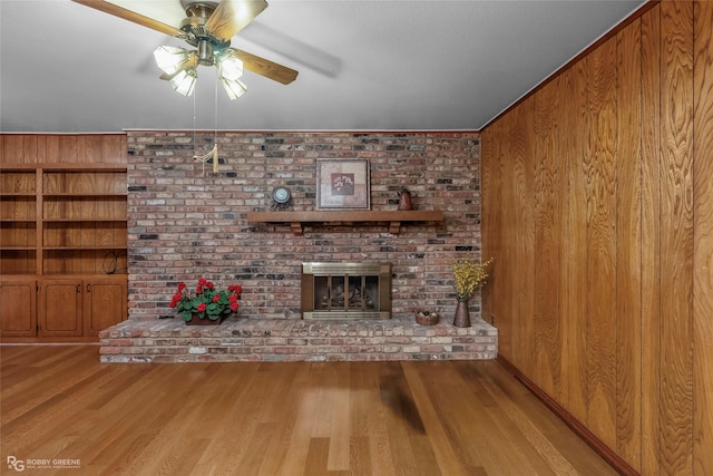 2007 Venus Dr, Bossier City, LA 71112 - unfurnished living room with a brick fireplace, wood finished floors, ceiling fan, and wooden walls