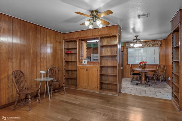 2007 Venus Dr, Bossier City, LA 71112 - dining room with a ceiling fan, light wood-style floors, wood walls, and visible vents