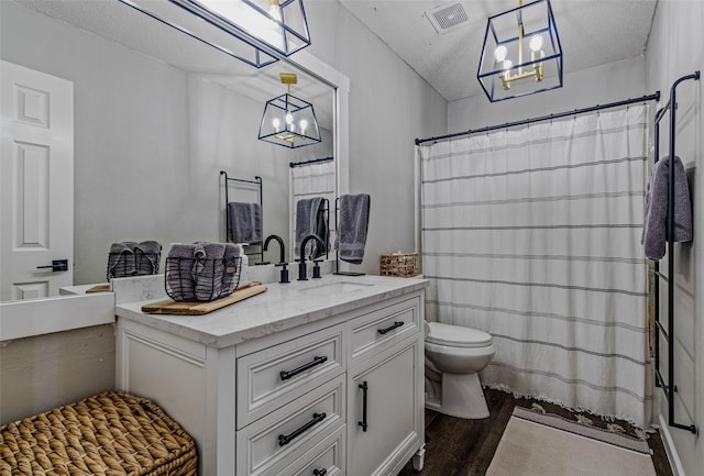 139 Wembley Way, Rockwall, TX 75032 - full bathroom featuring toilet, visible vents, a notable chandelier, wood finished floors, and vanity