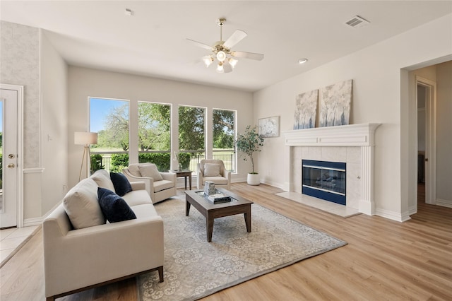 2110 Watercrest Ct, Keller, TX 76248 - living area with wood finished floors, a tiled fireplace, baseboards, and ceiling fan