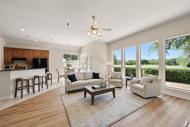 2110 Watercrest Ct, Keller, TX 76248 - living area with light wood finished floors, wallpapered walls, a ceiling fan, and visible vents