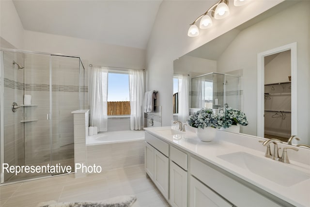 bathroom with a bath, double vanity, a stall shower, and a sink