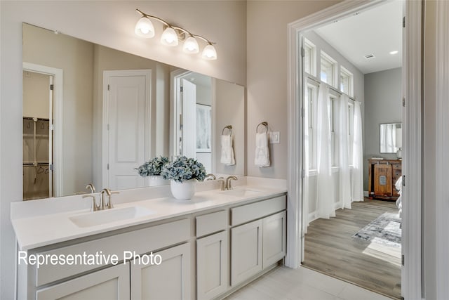 full bathroom featuring visible vents, a sink, a closet, and double vanity