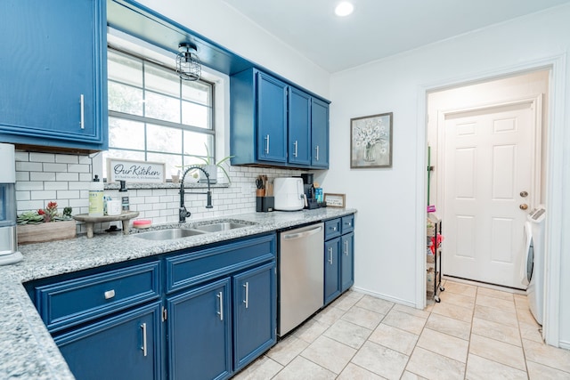 kitchen with tasteful backsplash, a sink, blue cabinets, dishwasher, and washer / clothes dryer