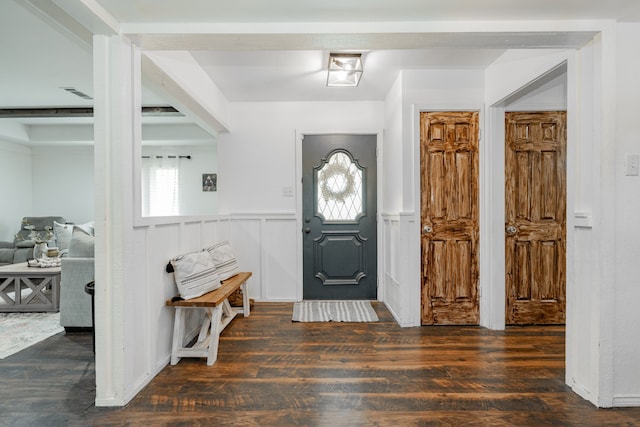 foyer entrance featuring a wainscoted wall, wood finished floors, and a decorative wall
