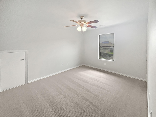 carpeted spare room featuring visible vents, baseboards, and ceiling fan