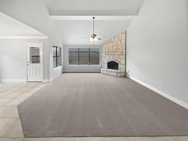 unfurnished living room featuring baseboards, a stone fireplace, lofted ceiling with beams, and ceiling fan