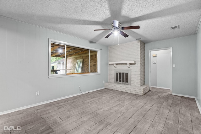 1908 Bey St, Bossier City, LA 71112 - unfurnished living room featuring a textured ceiling, ceiling fan, visible vents, a fireplace, and wood finished floors