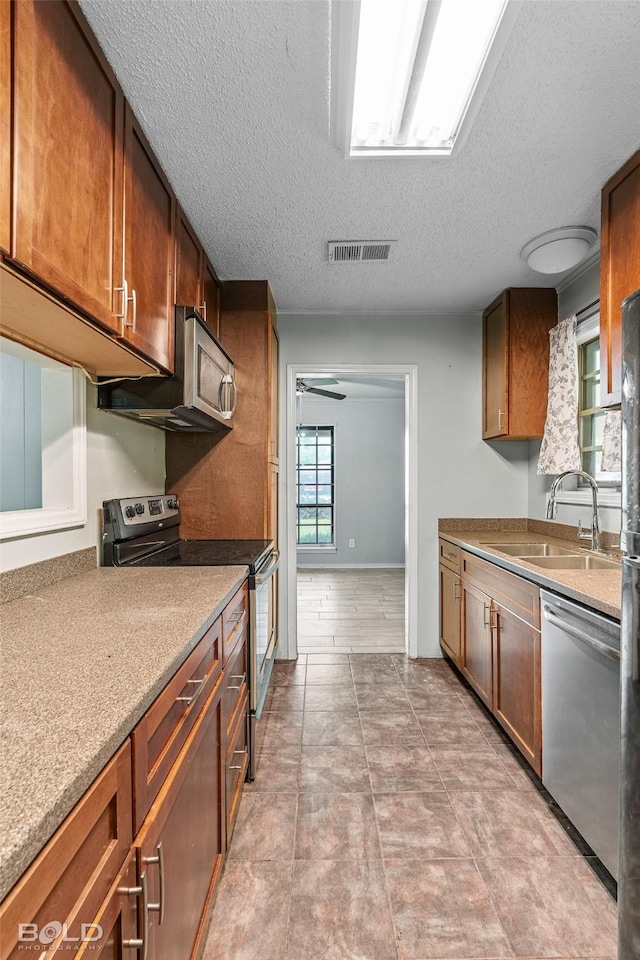 1908 Bey St, Bossier City, LA 71112 - kitchen featuring a sink, brown cabinetry, visible vents, a textured ceiling, and appliances with stainless steel finishes