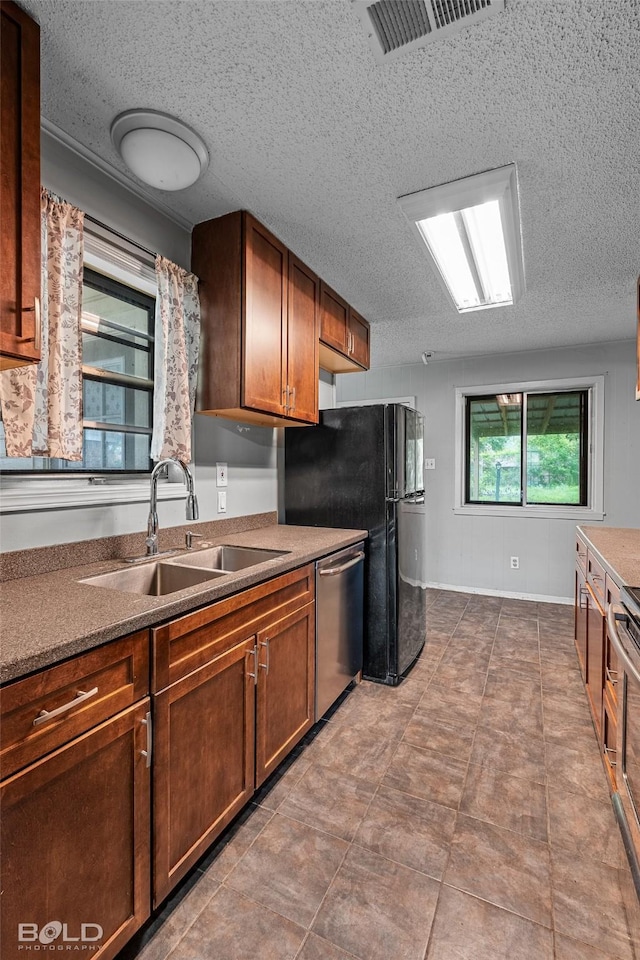 1908 Bey St, Bossier City, LA 71112 - kitchen with brown cabinetry, dishwasher, a sink, visible vents, and a textured ceiling