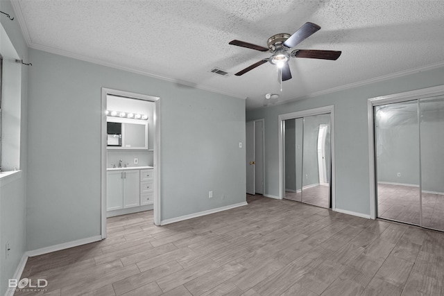 1908 Bey St, Bossier City, LA 71112 - unfurnished bedroom featuring a textured ceiling, visible vents, two closets, and light wood-style flooring
