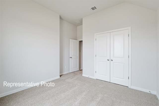 4933 Hitching Post Dr, Fort Worth, TX 76036 - unfurnished bedroom featuring a closet, light colored carpet, baseboards, lofted ceiling, and visible vents