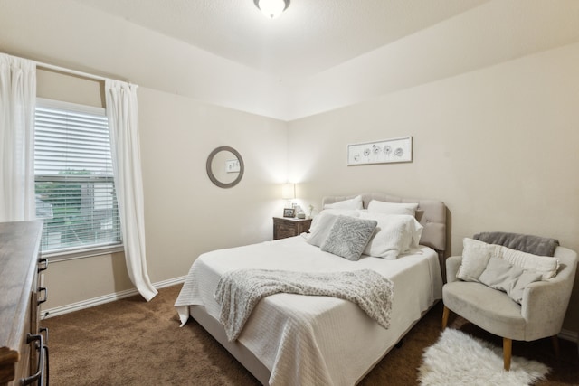 bedroom featuring dark carpet and baseboards
