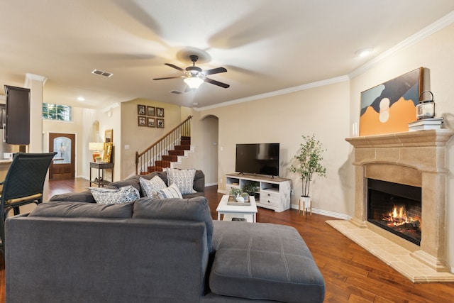 living room featuring visible vents, stairs, dark wood-style flooring, a fireplace, and arched walkways