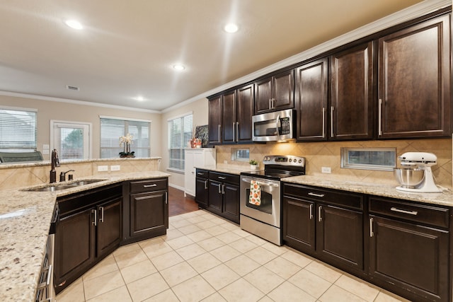 kitchen featuring a sink, appliances with stainless steel finishes, tasteful backsplash, and crown molding