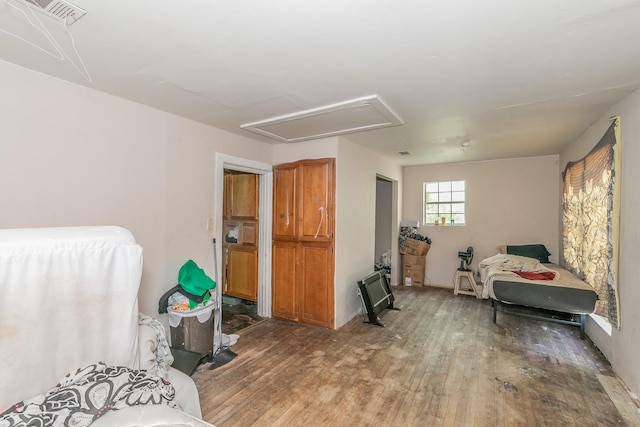 bedroom with attic access, hardwood / wood-style flooring, and visible vents