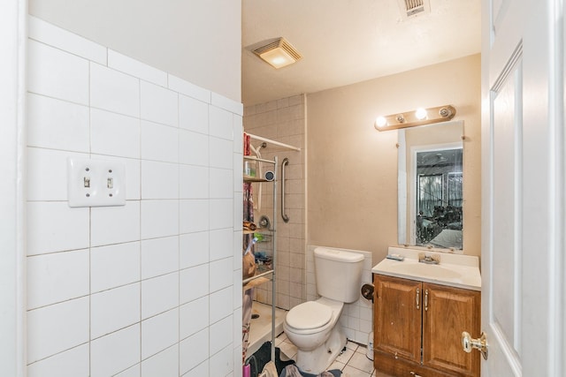 bathroom featuring tile patterned floors, toilet, visible vents, and tiled shower