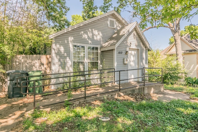 rear view of house featuring fence