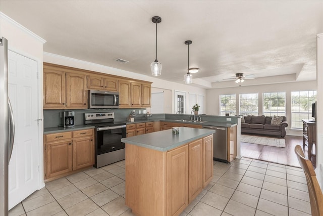 kitchen featuring visible vents, a sink, light tile patterned flooring, a peninsula, and appliances with stainless steel finishes