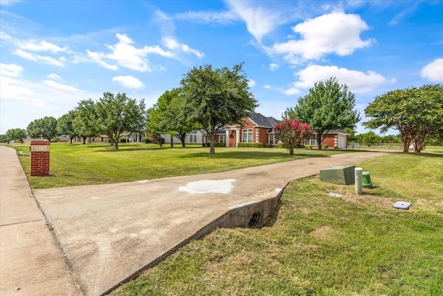 view of community with a garage, a yard, and driveway