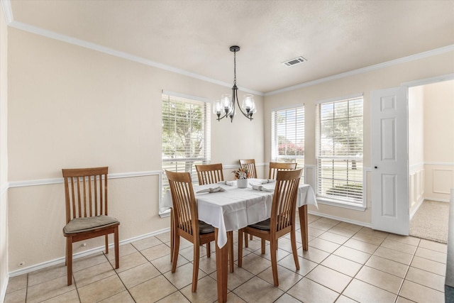 dining room with an inviting chandelier, crown molding, visible vents, and light tile patterned floors