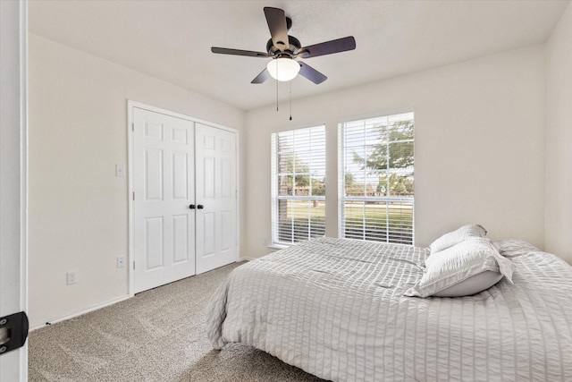 carpeted bedroom featuring baseboards, a closet, and ceiling fan