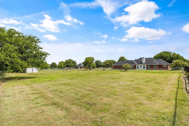 view of yard with an outdoor structure, fence, and a storage shed
